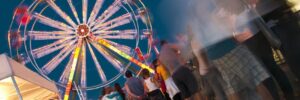 people wating in line at the amusement park to get on the rides