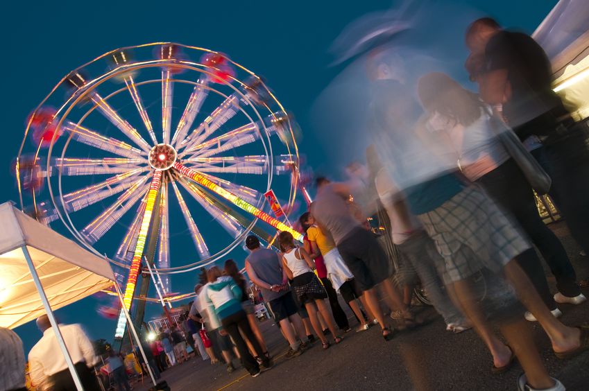 people wating in line at the amusement park to get on the rides
