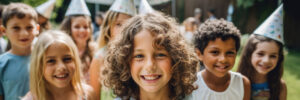 Close up photo of a group of small and big kids at a backyard birthday party